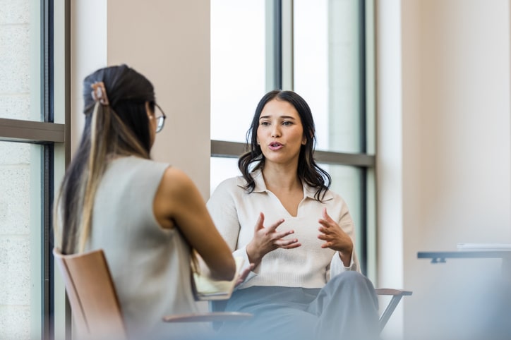 Two women speaking to one another