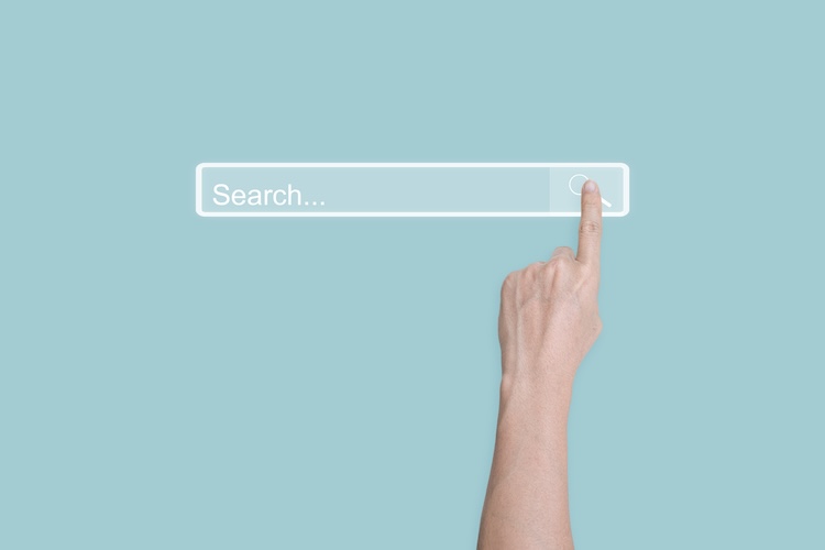 Person's finger clicking an AI-created search bar on a light blue background