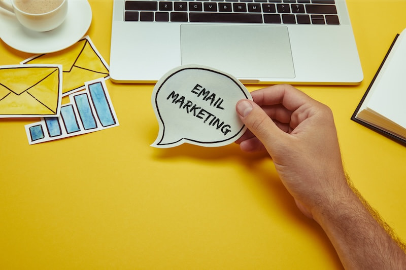 Human hand holding a speech bubble saying "lead generation" in front at a workspace. 