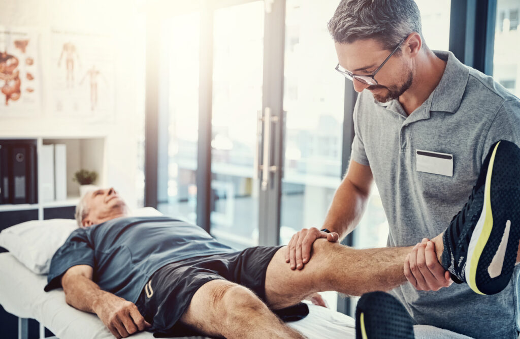 Male physiotherapist treating a senior male patient